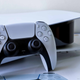 A DualSense controller leans against a PS5 on top of PlayStation 5 retail packaging.